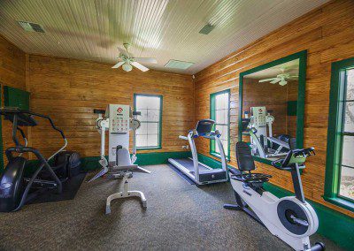 photo of the workout room with a treadmill, elliptical machine, recumbent bike, and weight machine at the Great Oaks Recovery Center - drug addiction treatment - drug rehab near houston, tx