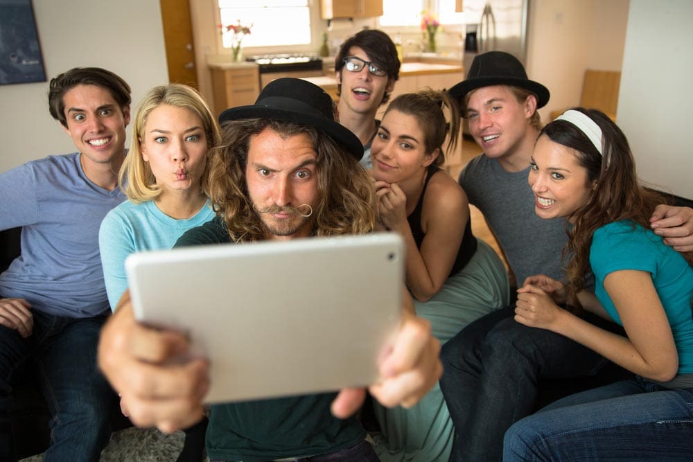 group of young adults taking a silly selfie with a tablet - fun in sobriety - great oaks recovery center - houston drug rehab - texas alcohol addiction treatment center - long-term sobriety and addiction recovery