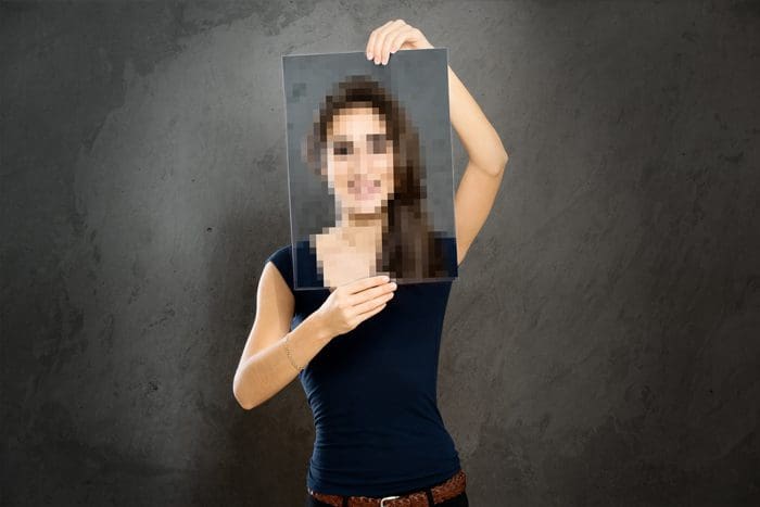 Should You Keep Your Sobriety Confidential? - woman holding pixelated pic of self