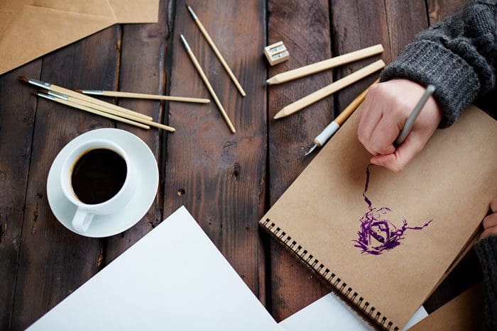 Top-5-Activities-for-Self-Expression-in-Recovery - hand drawing on wooden table top with coffee