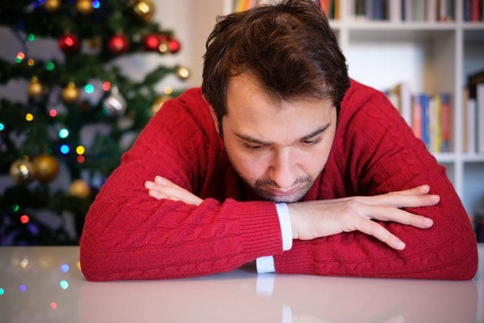 How-to-Recognize-Signs-of-Addiction-This-Holiday-Season - man in red sweater sad christmas