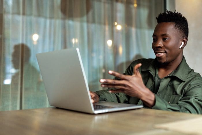 African American young man using video chat on his laptop - loneliness