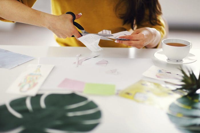 woman cutting out magazine pictures for vision board - recovery during COVID-19