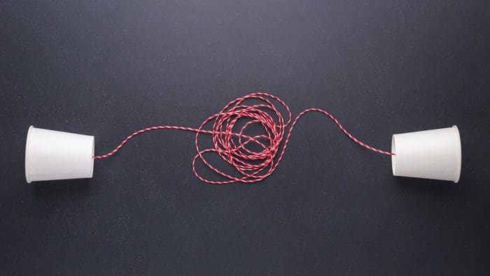 white cups attached with red string - communication