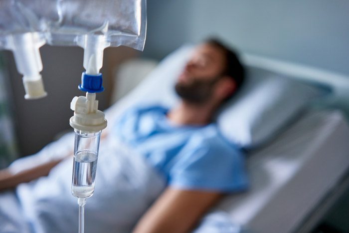 man in hospital bed getting IV fluids - Acute Endocarditis