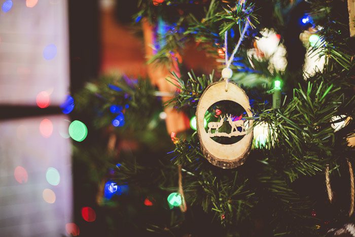 close up of wooden Christmas ornament on lit tree - recovery