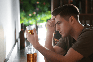 Guy holding a glass - anxiety