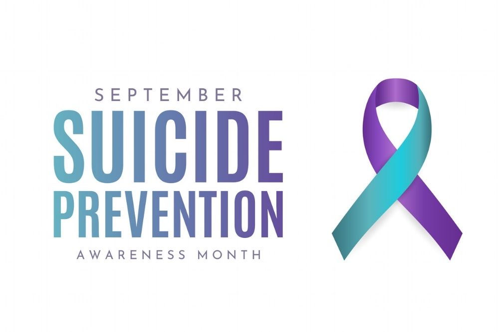 Purple and teal ribbon with text reading ‘September Suicide Prevention Awareness Month.’