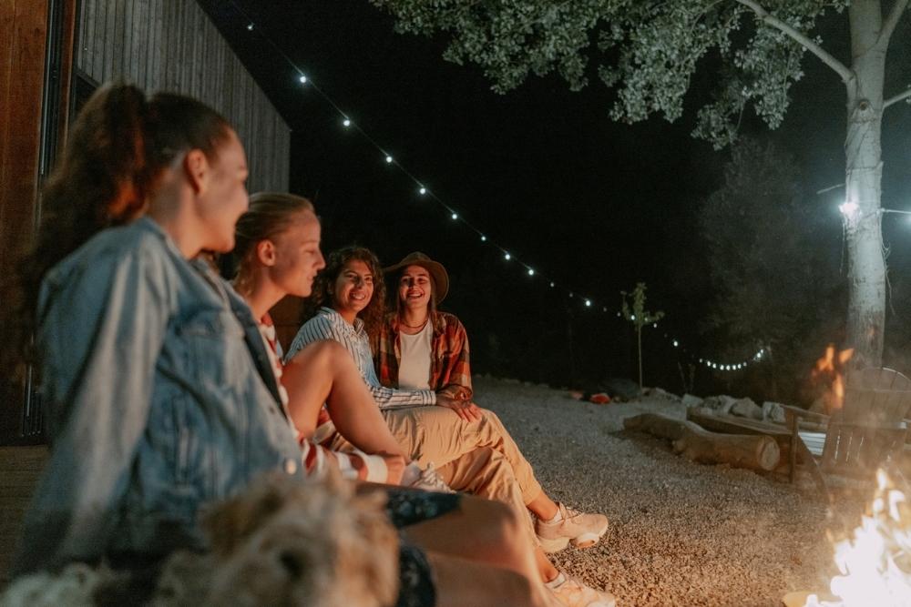 Photo of friends relaxing by the campfire and having a great time.